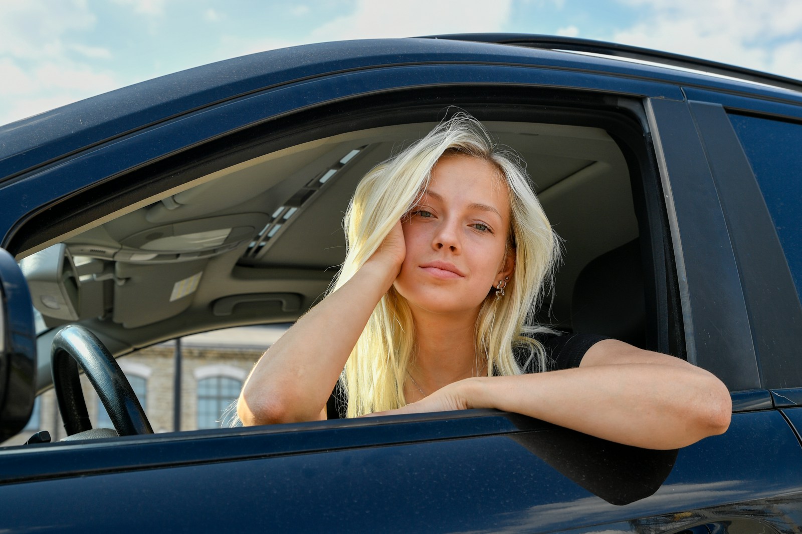 A young woman with blonde hair in a car