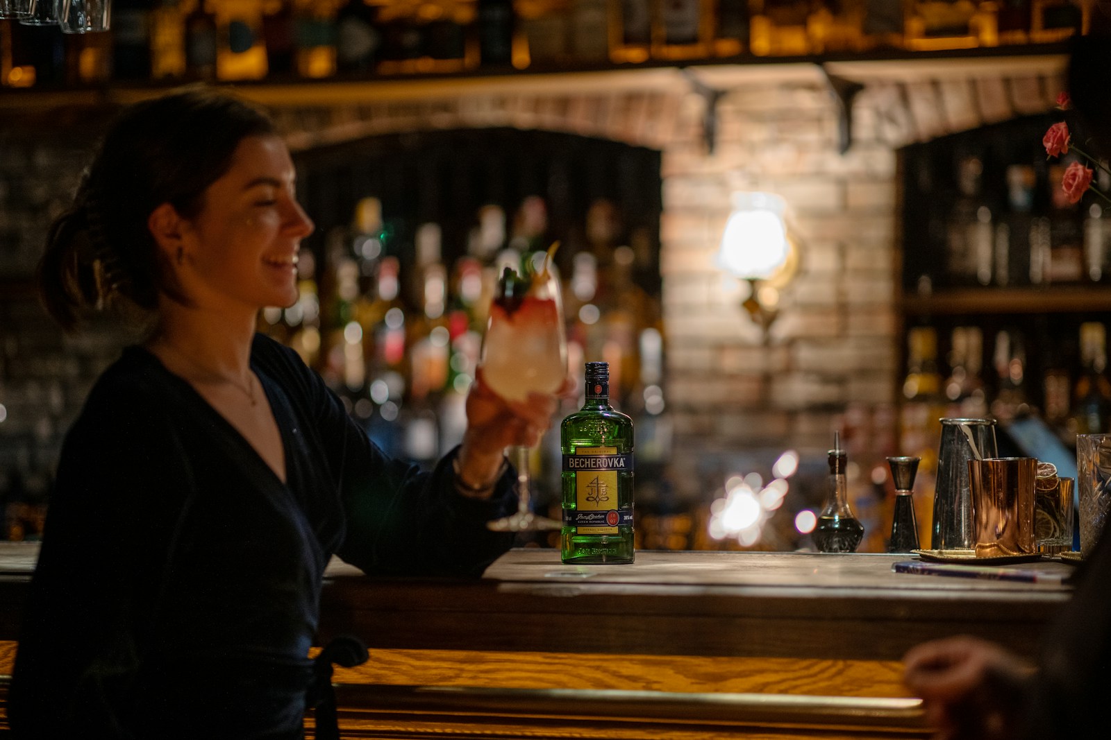 a woman sitting at a bar holding a drink