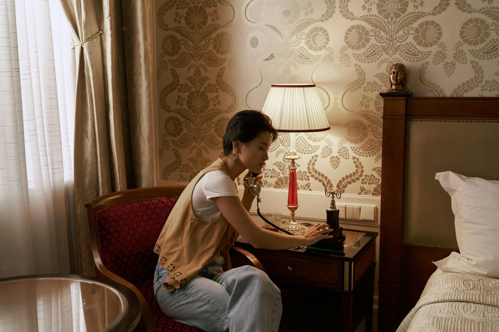 Elegant bedroom with a woman on a vintage phone, exuding retro charm.