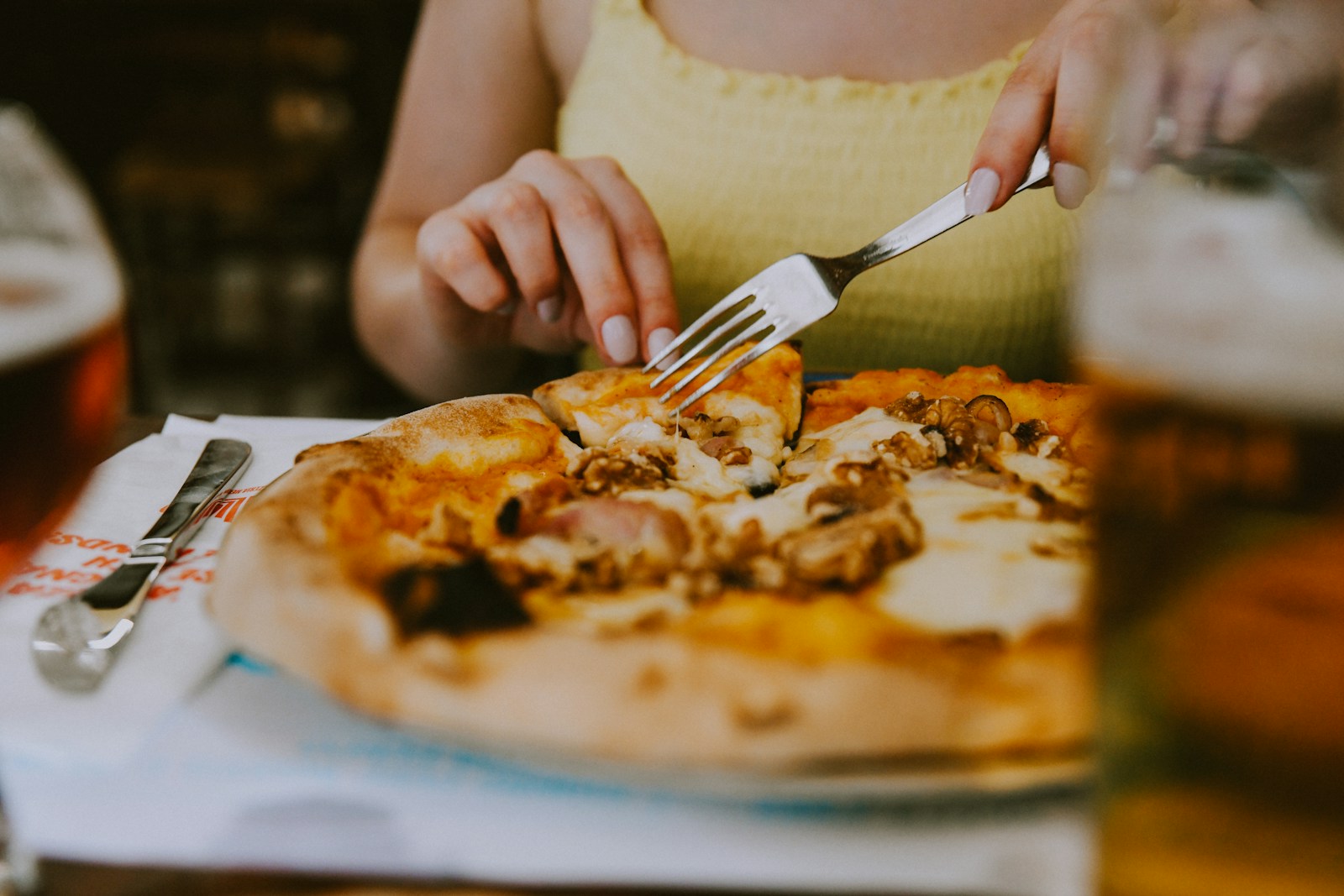 A woman sitting at a table with a plate of pizza