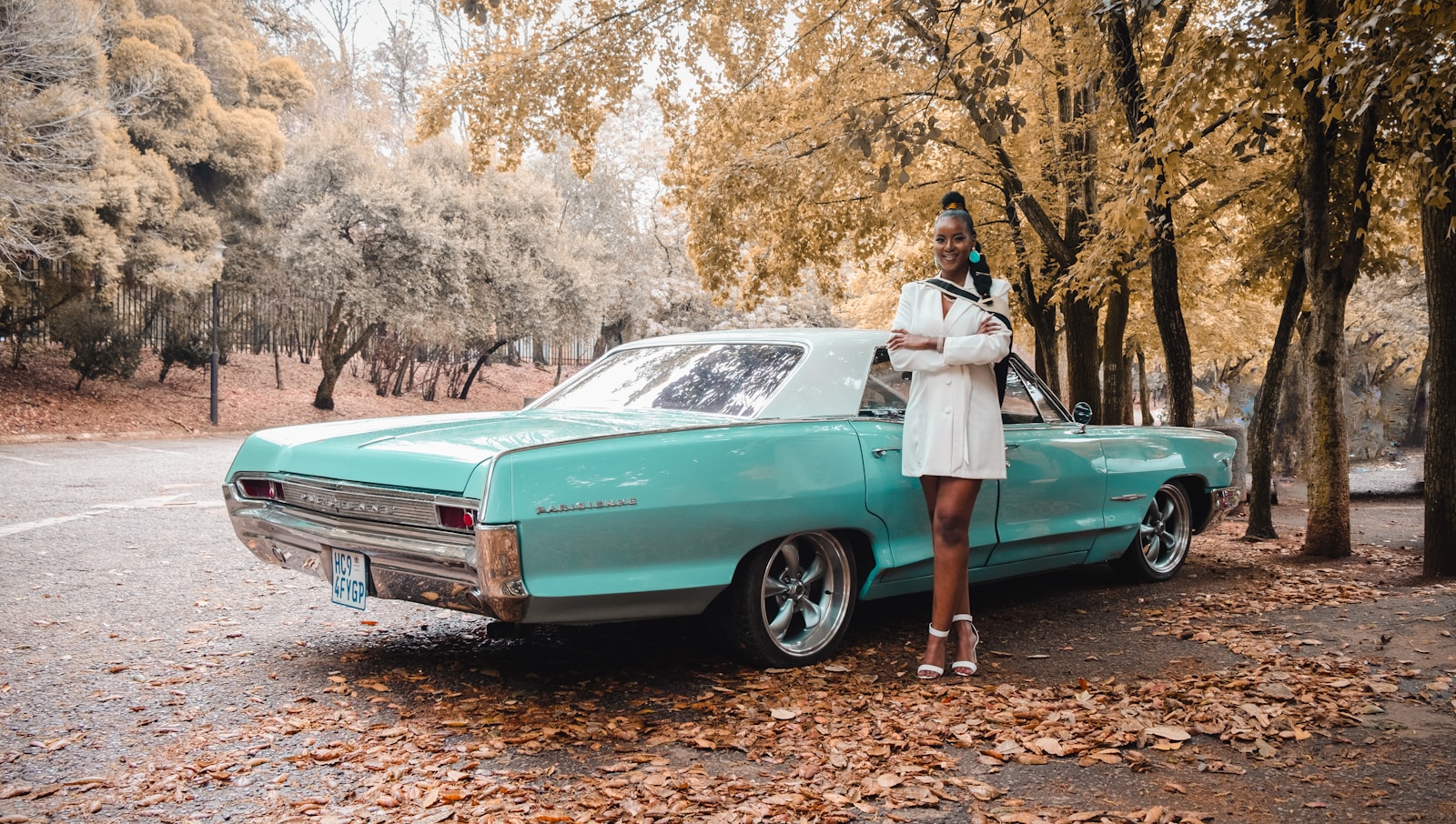 a woman standing next to a turquoise car