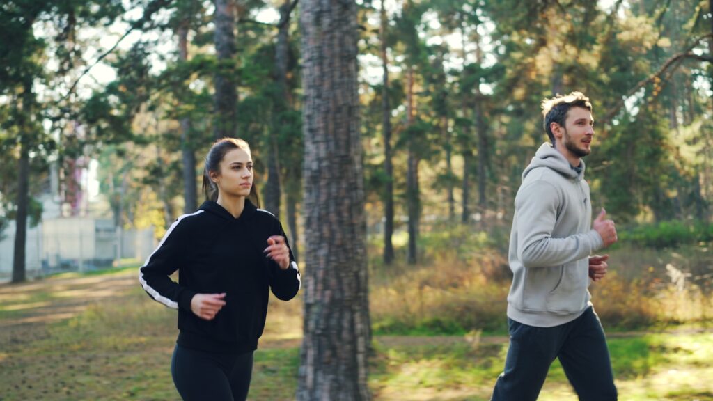 Man and woman jogging together in a park.