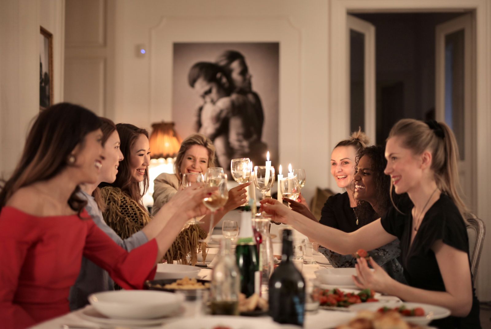 A group of women celebrating with wine at an elegant indoor dinner party, enjoying friendship and laughter.