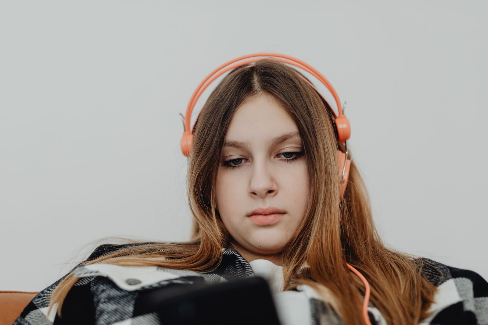 Teen girl relaxing with headphones, enjoying music. Indoor leisure and lifestyle.