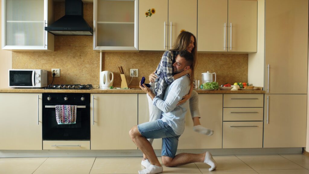 Man proposes to woman in a modern kitchen.