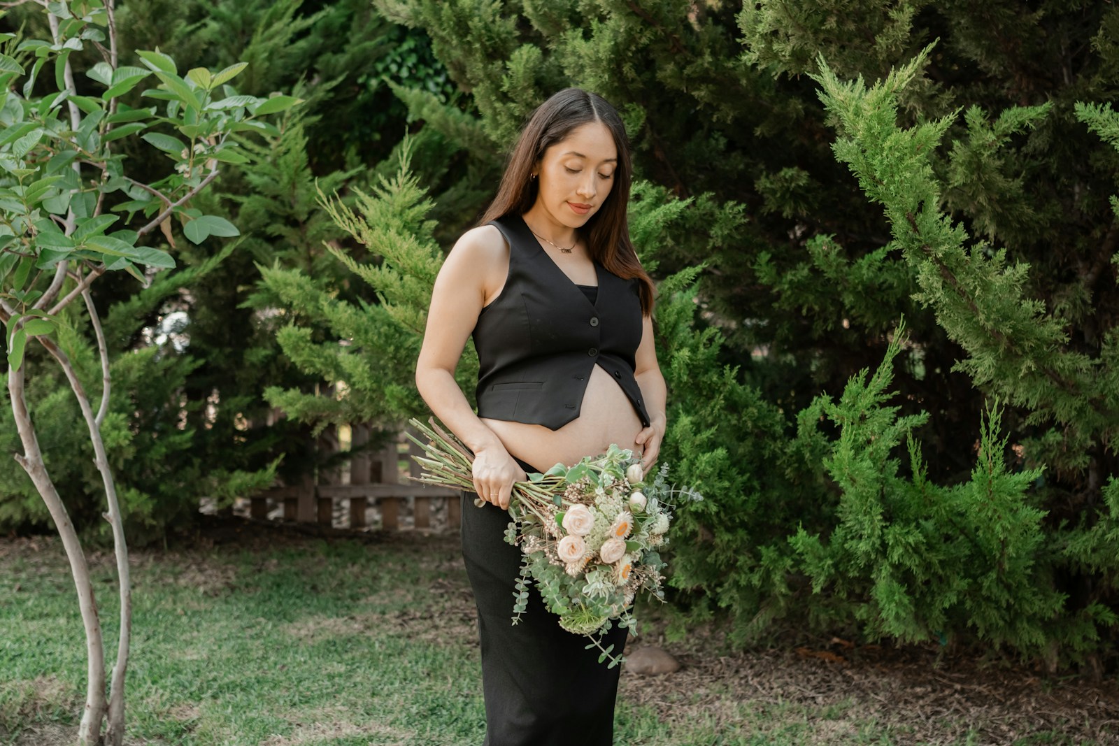 A pregnant woman holding a bouquet of flowers
