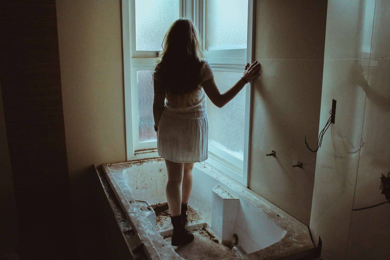 woman in black and white stripe tank top and white skirt standing in front of mirror