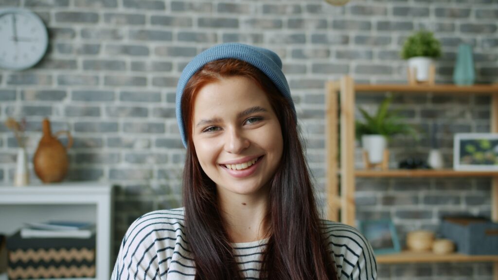 Young woman with red hair wearing a blue beanie