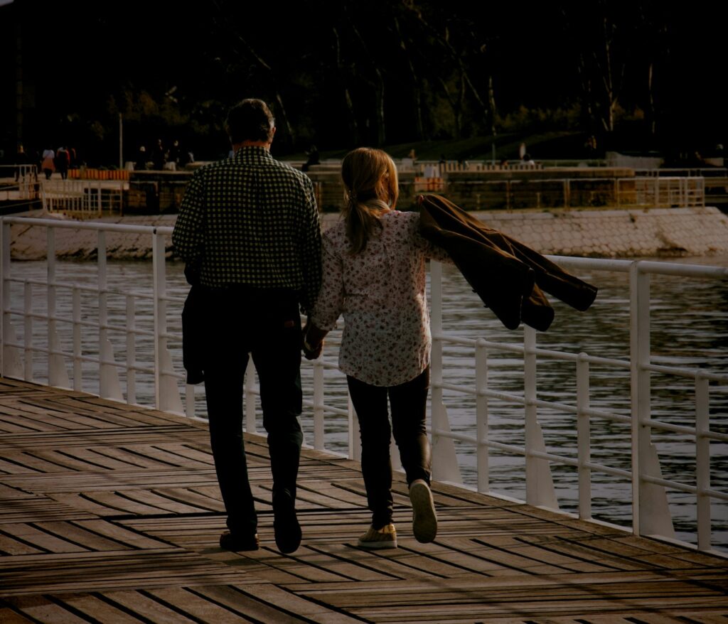 man and woman walking on wooden dock during daytime