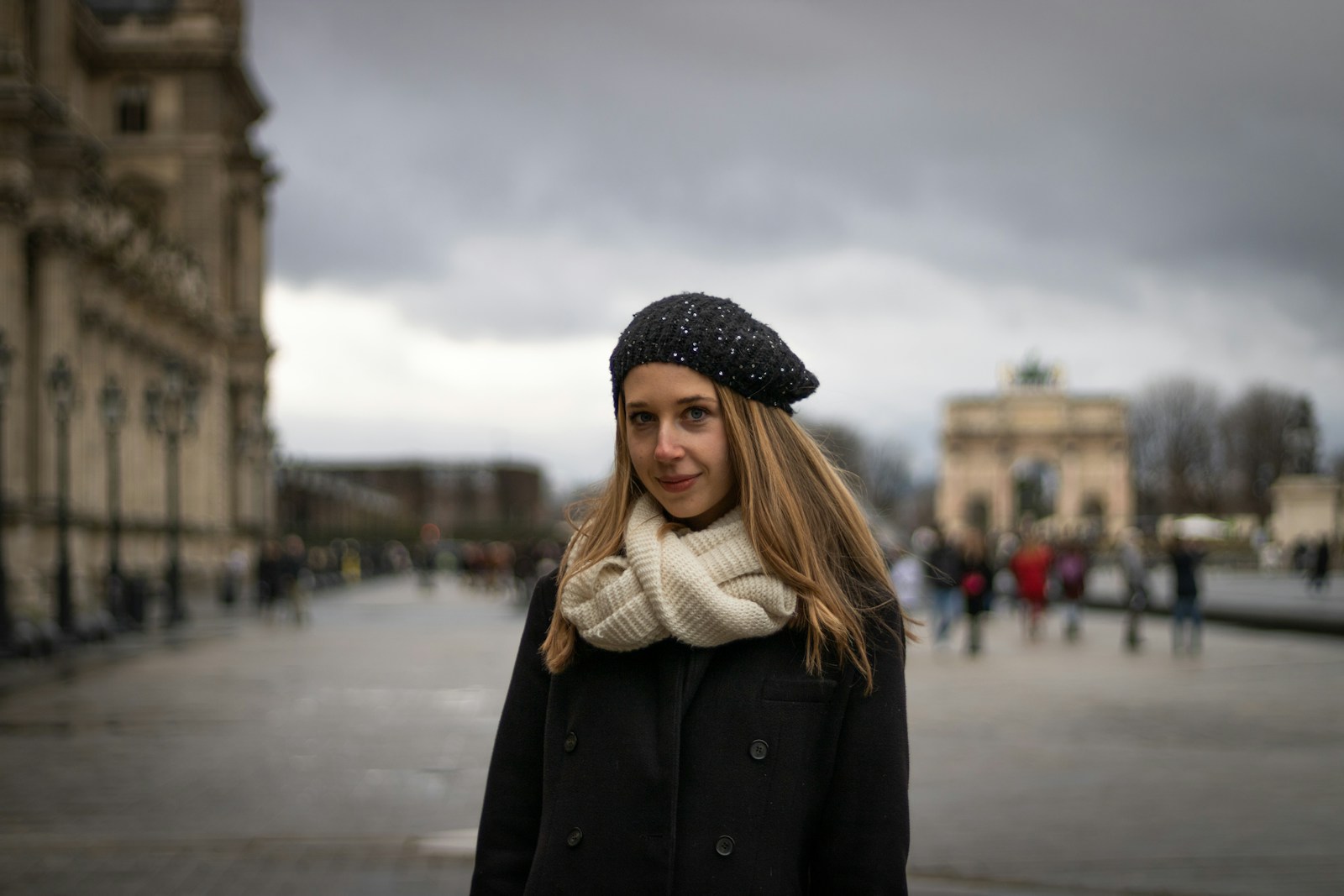 a woman in a black coat and a white scarf