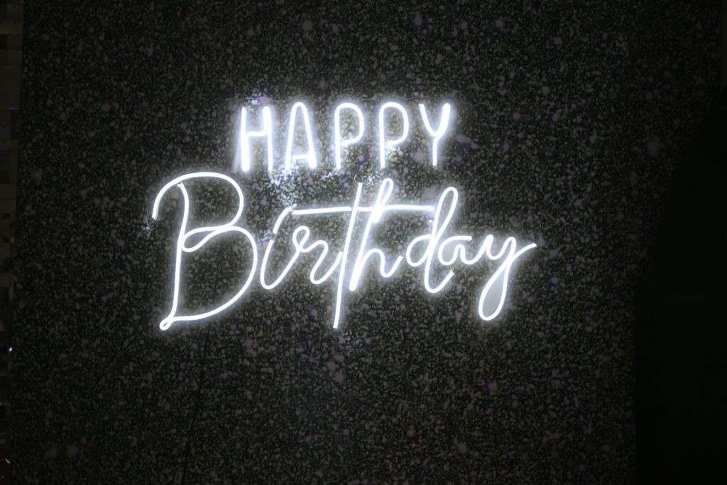 White neon "happy birthday" sign on dark background