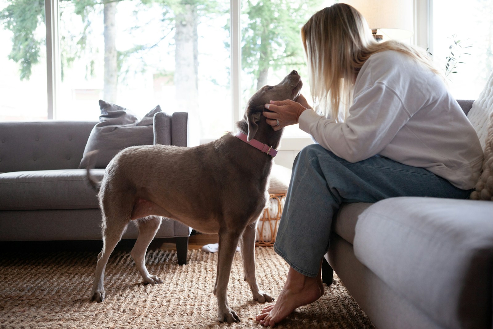 Woman pets her dog inside a home.