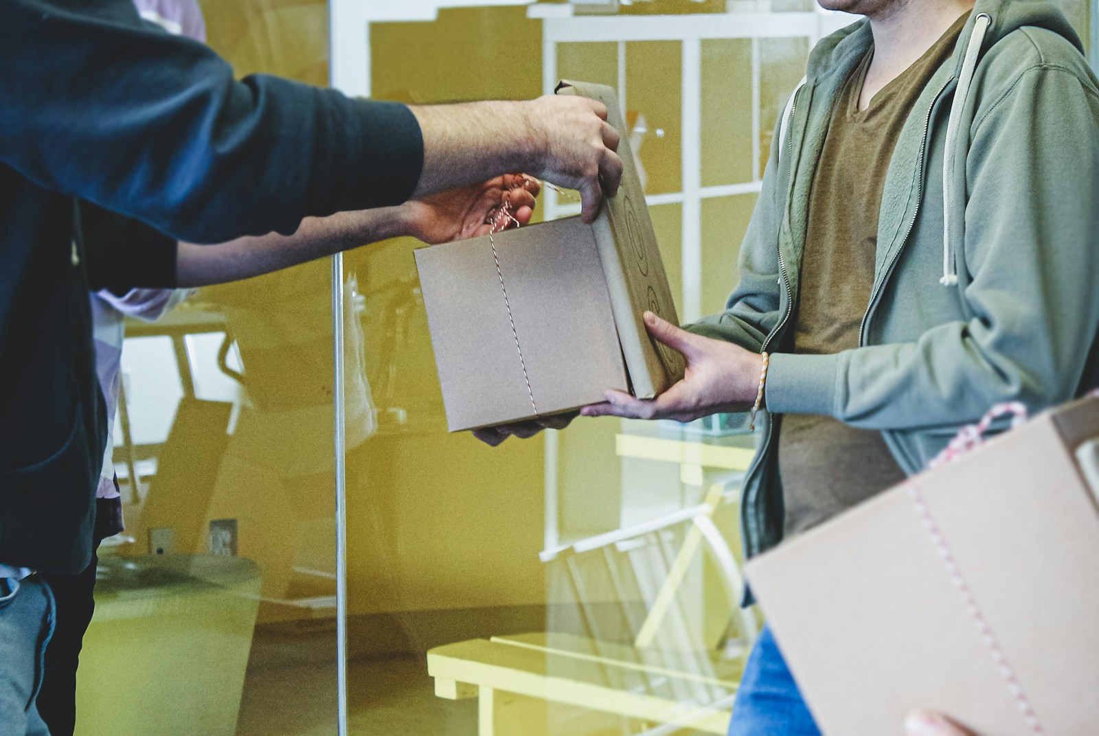 a man is handing a folder to another man
