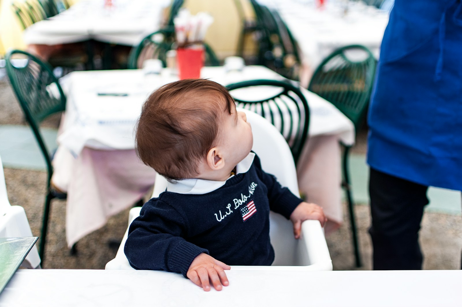 A baby sitting in a high chair at a table