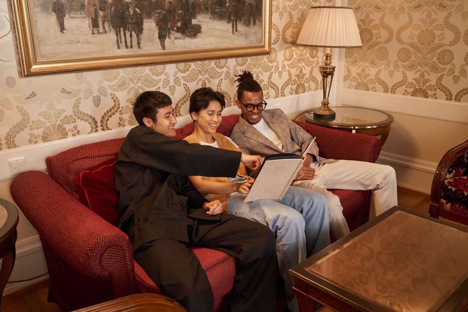 Three friends relax on a cozy couch, enjoying a pleasant conversation, creating a warm, inviting atmosphere.