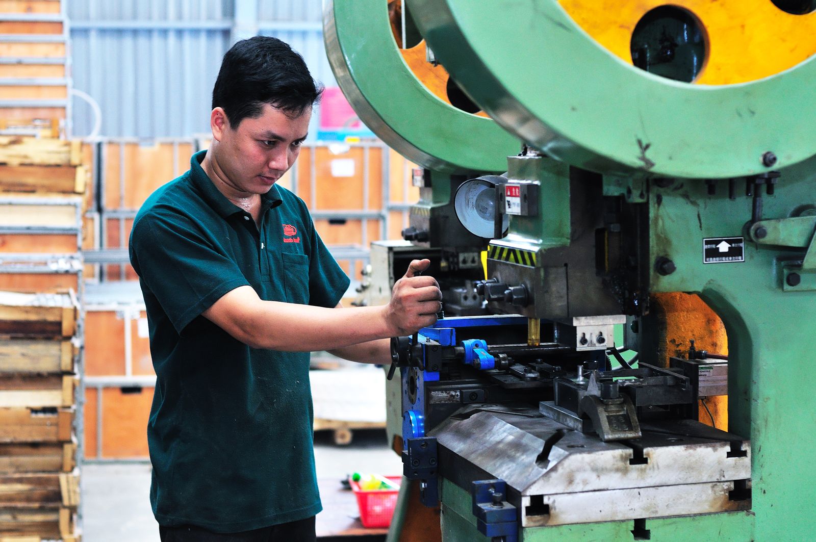 Man managing a machine in a factory setting, focusing on production.