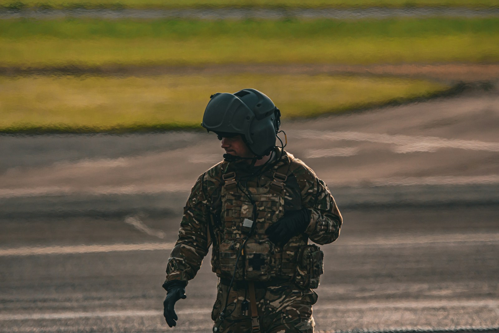 A man in camouflage walking across a street