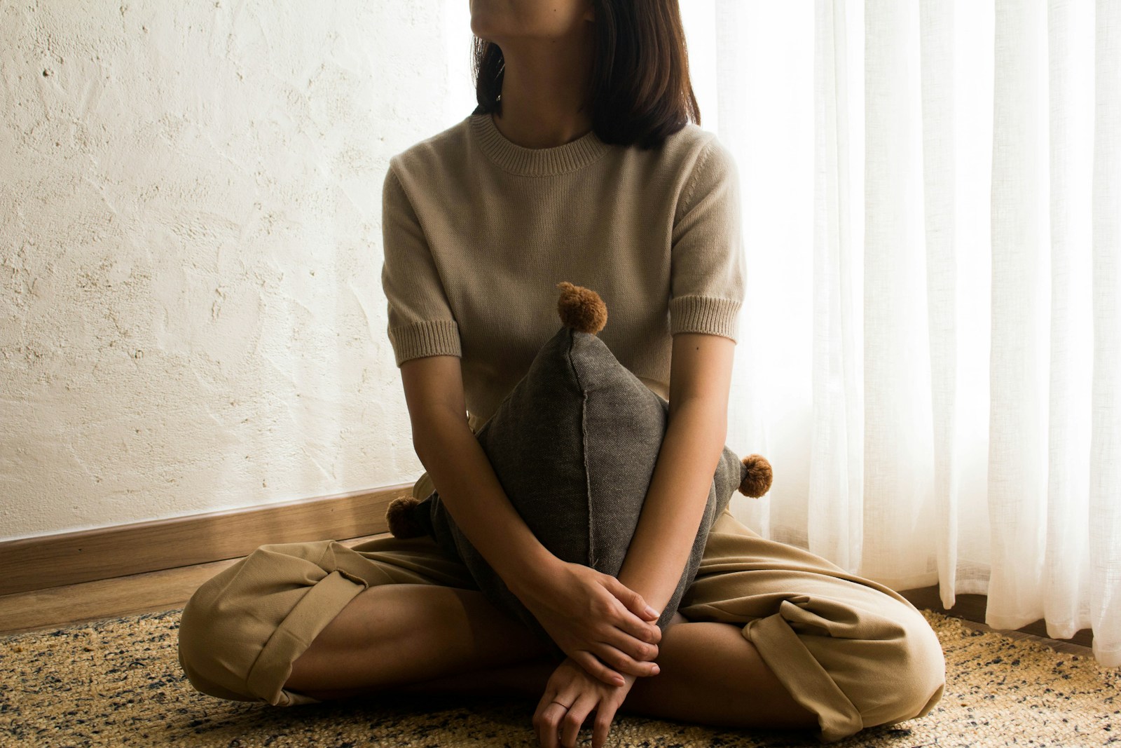woman in white knit sweater sitting on brown wooden seat