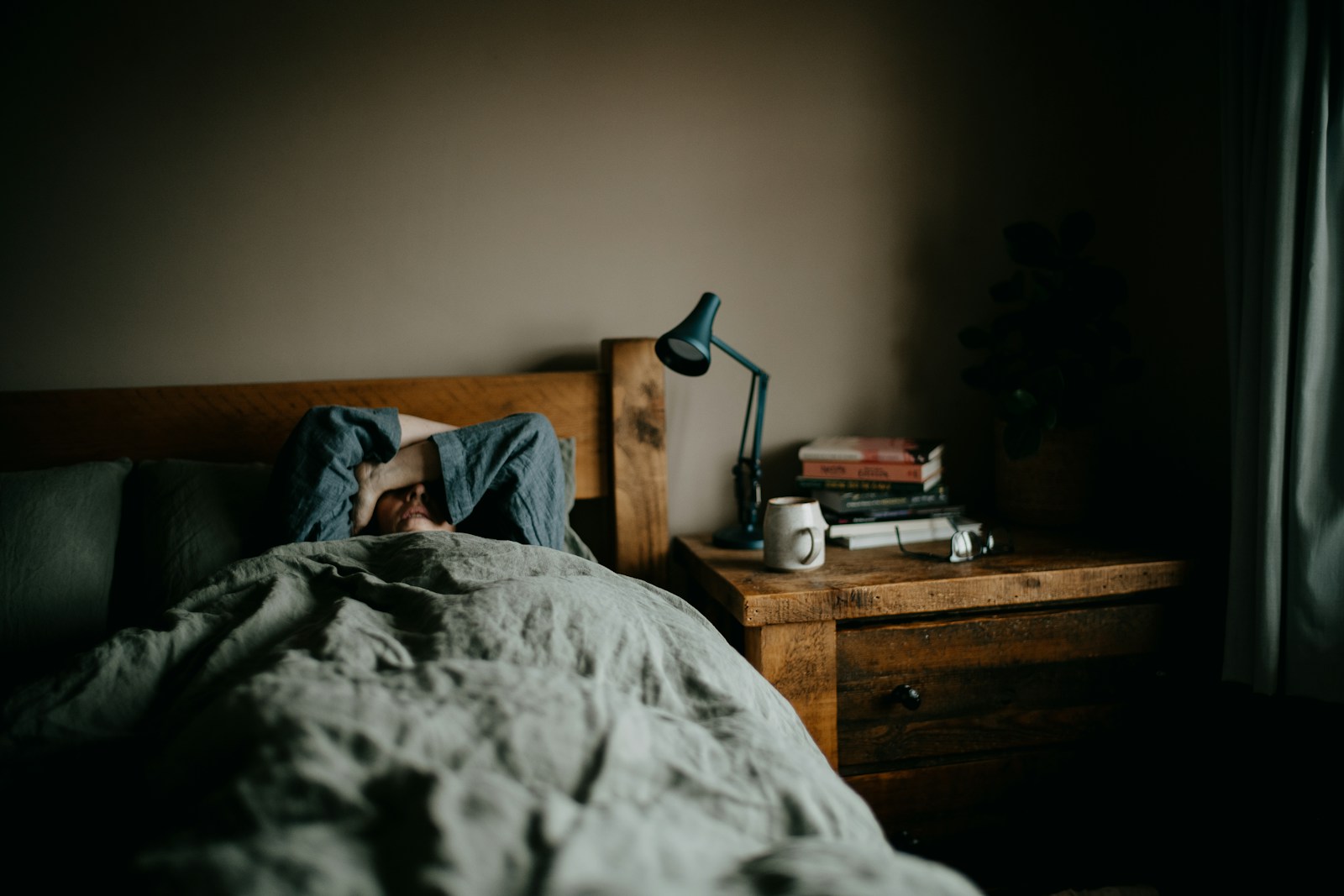 a person laying in bed under a blanket