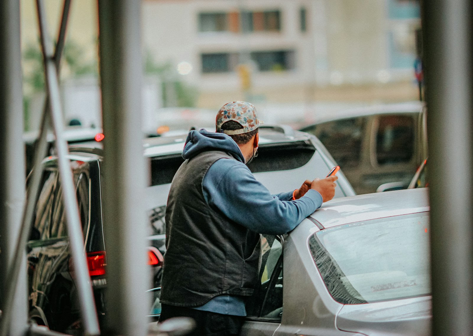 a man standing next to a car in a parking lot