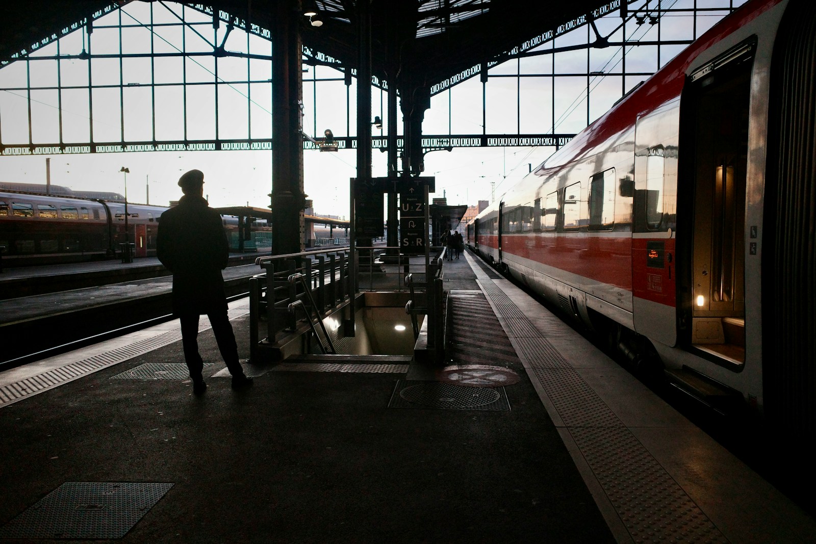 A man standing in a train station next to a train
