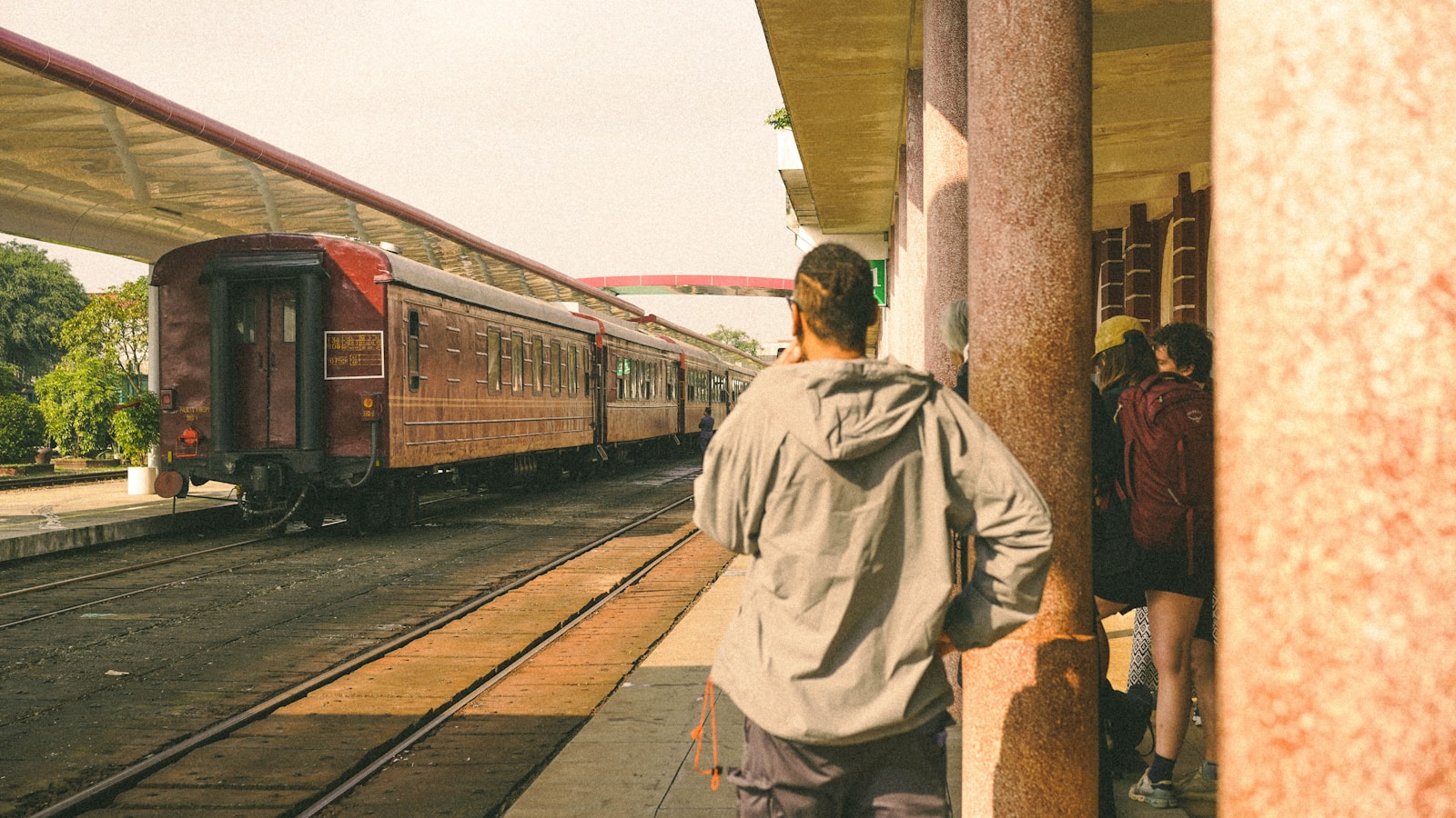 People wait for a train at a station platform.