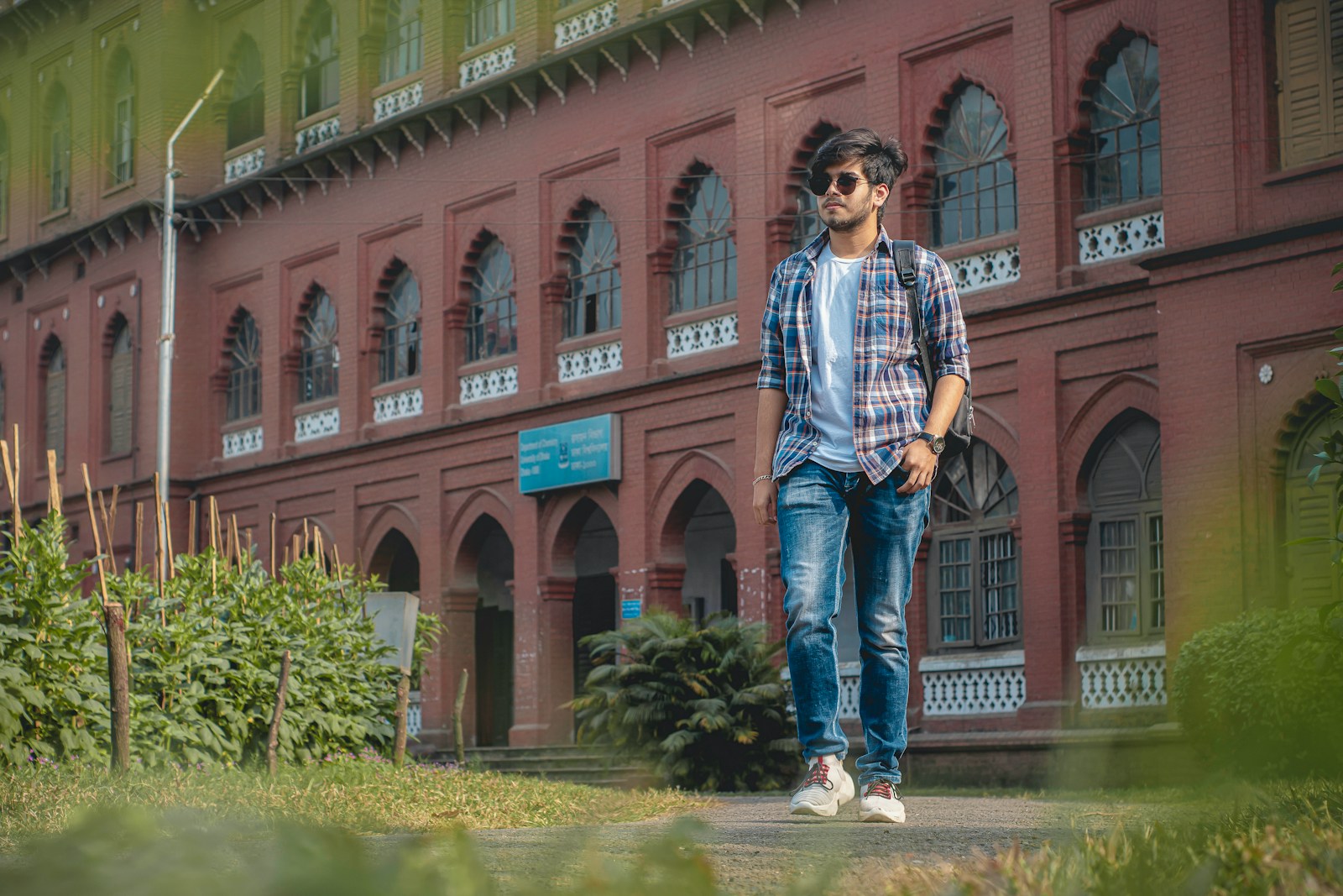 a man walking down a sidewalk in front of a building