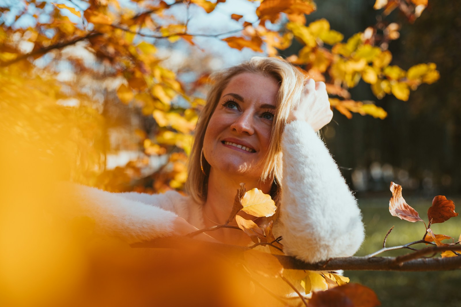 A woman in a bathrobe sitting on a tree branch