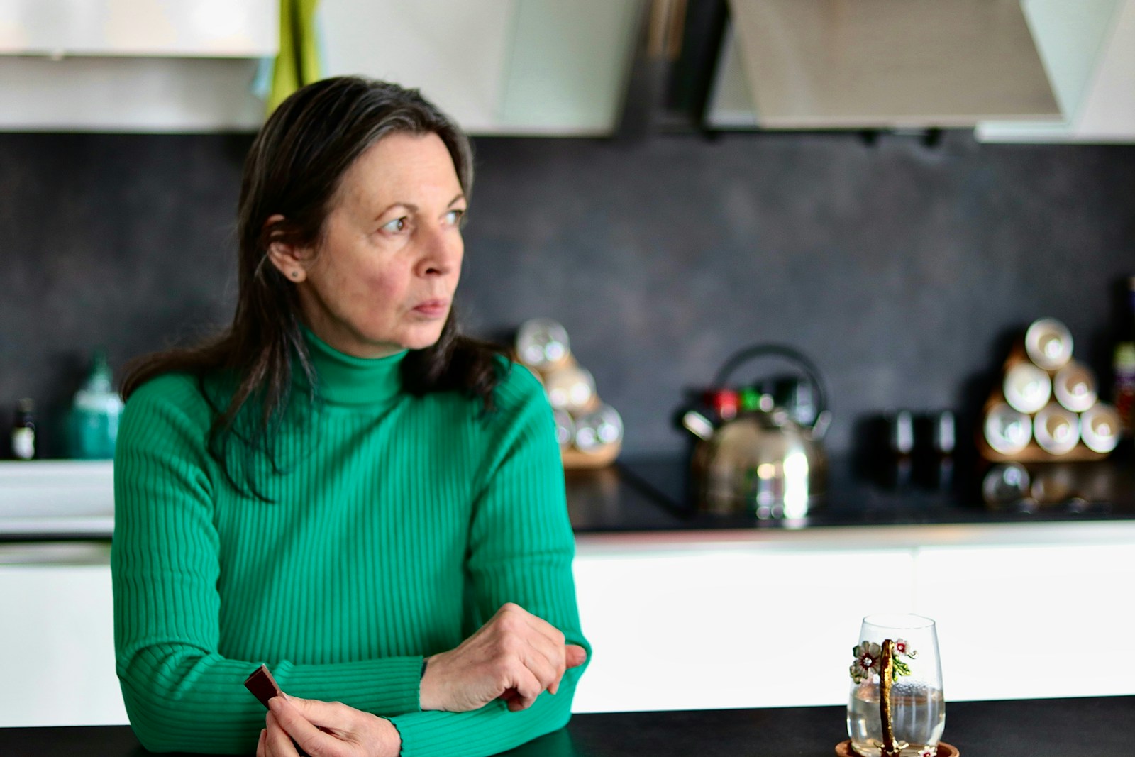 a woman sitting at a table in a kitchen