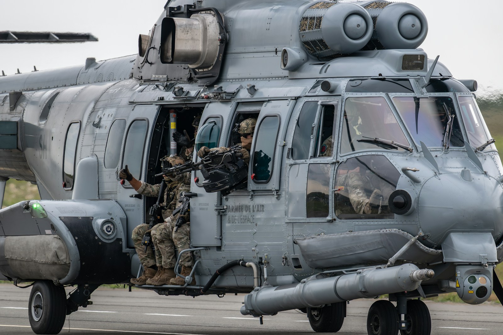 Military personnel prepare to exit a helicopter.