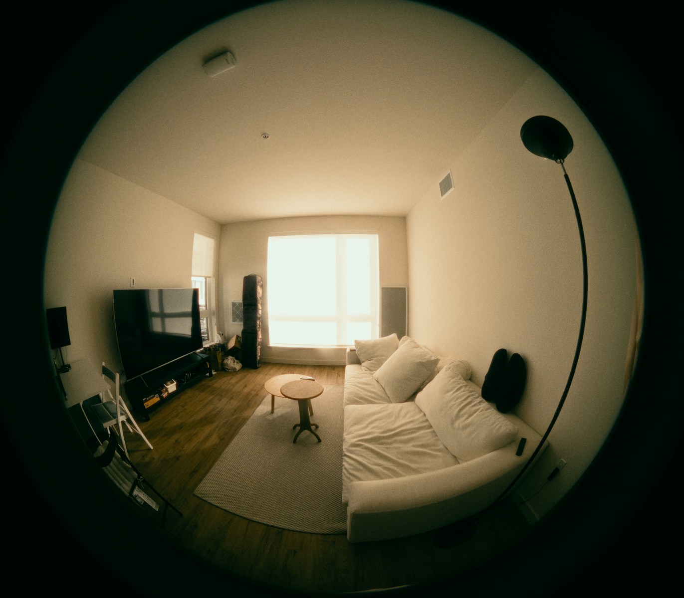 Modern living room with white sofa and large window.