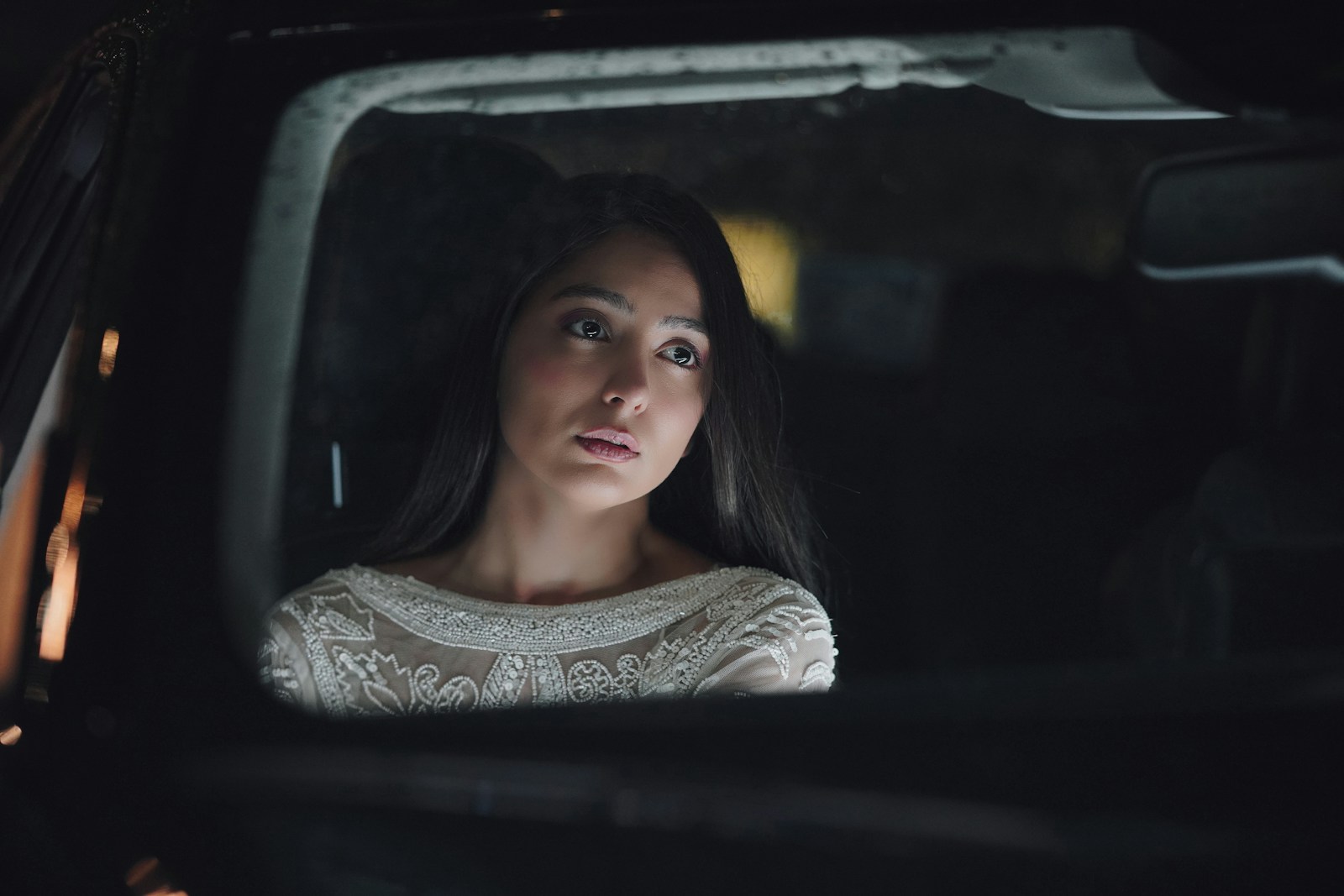 a woman sitting in a car looking out the window