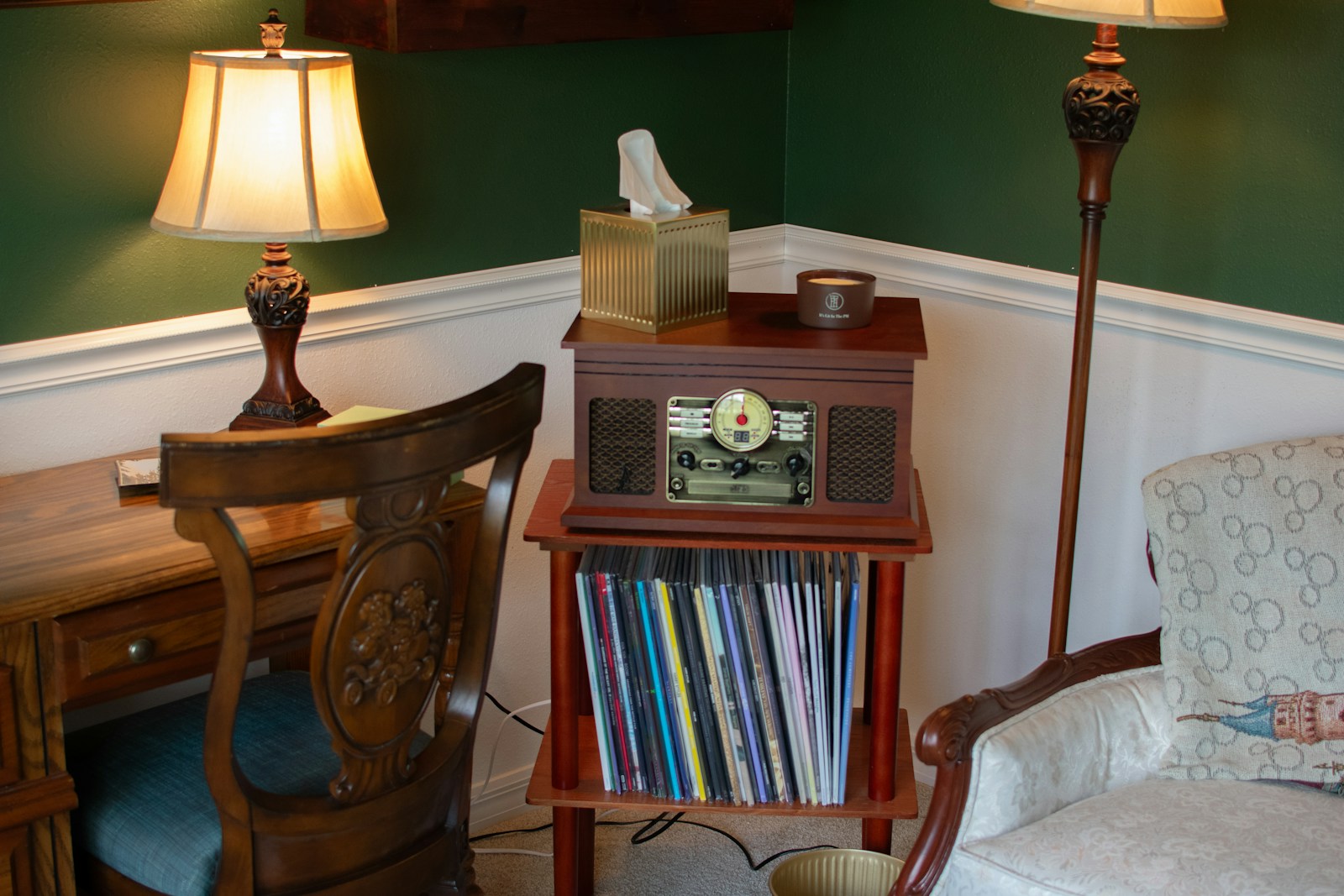 A room with a chair, lamp and a desk