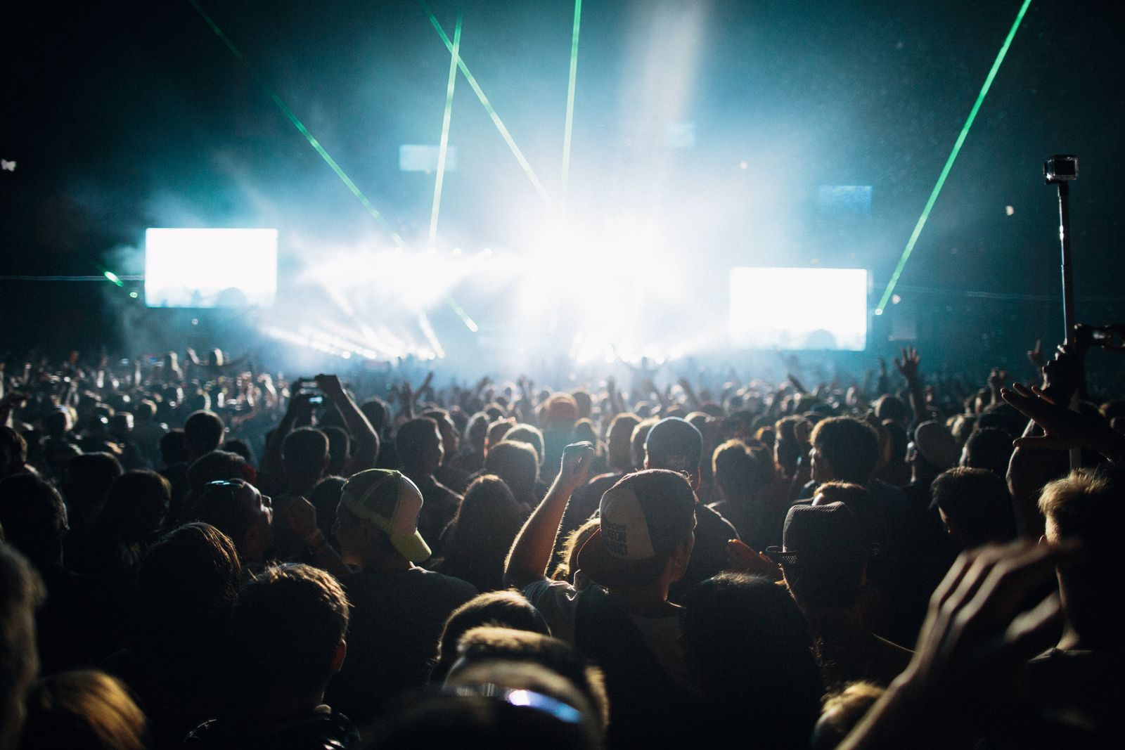 Thrilling live concert experience with a crowd under spectacular laser lights.