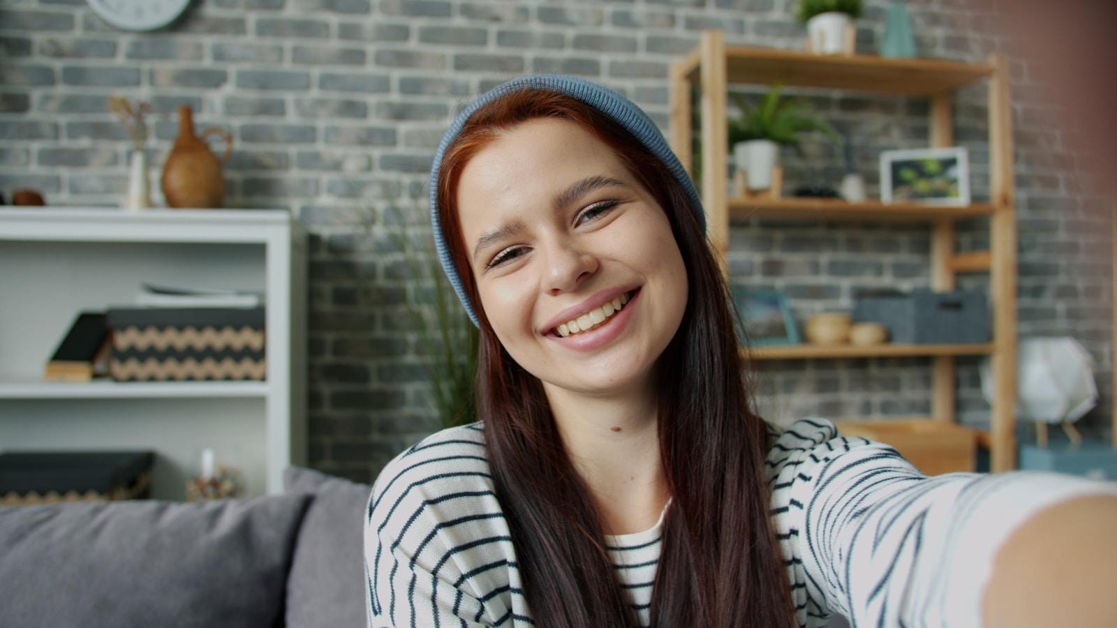 Young woman smiling and taking a selfie indoors