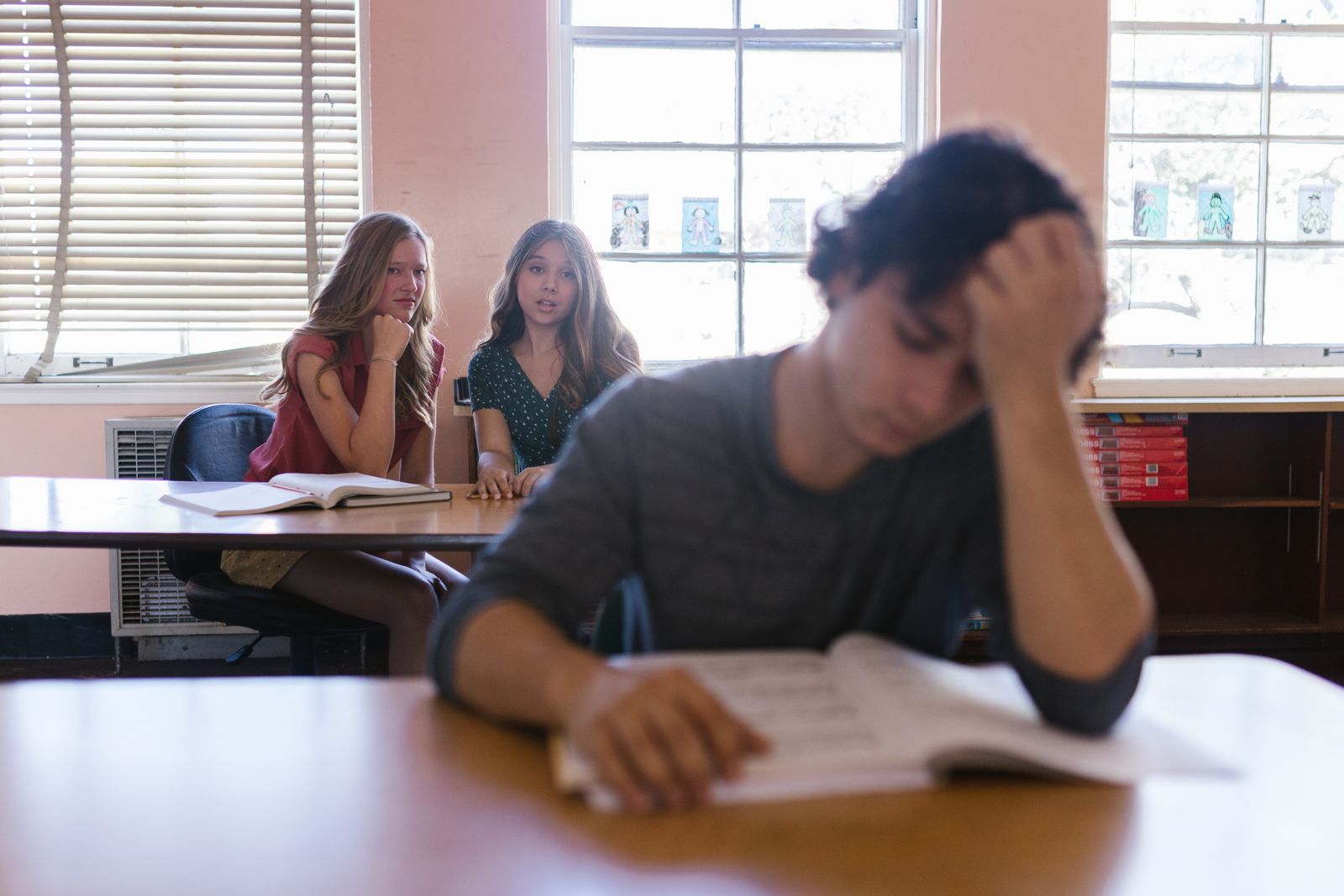Focused on a teenager feeling bullied in a classroom environment with peers.