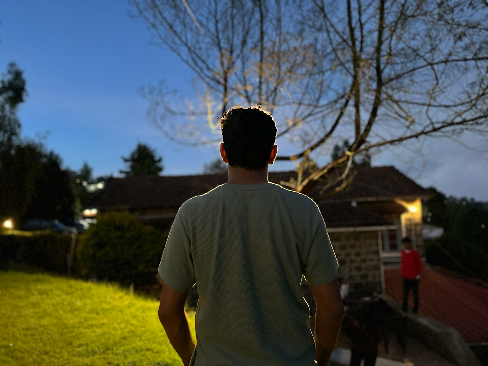 A man standing in a yard at night
