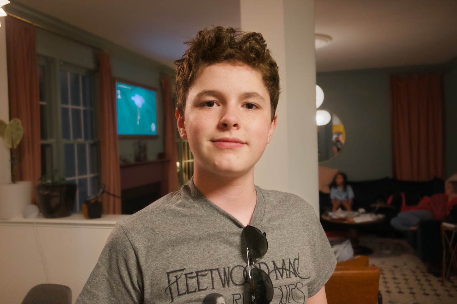 A young boy in a grey t-shirt smiles.