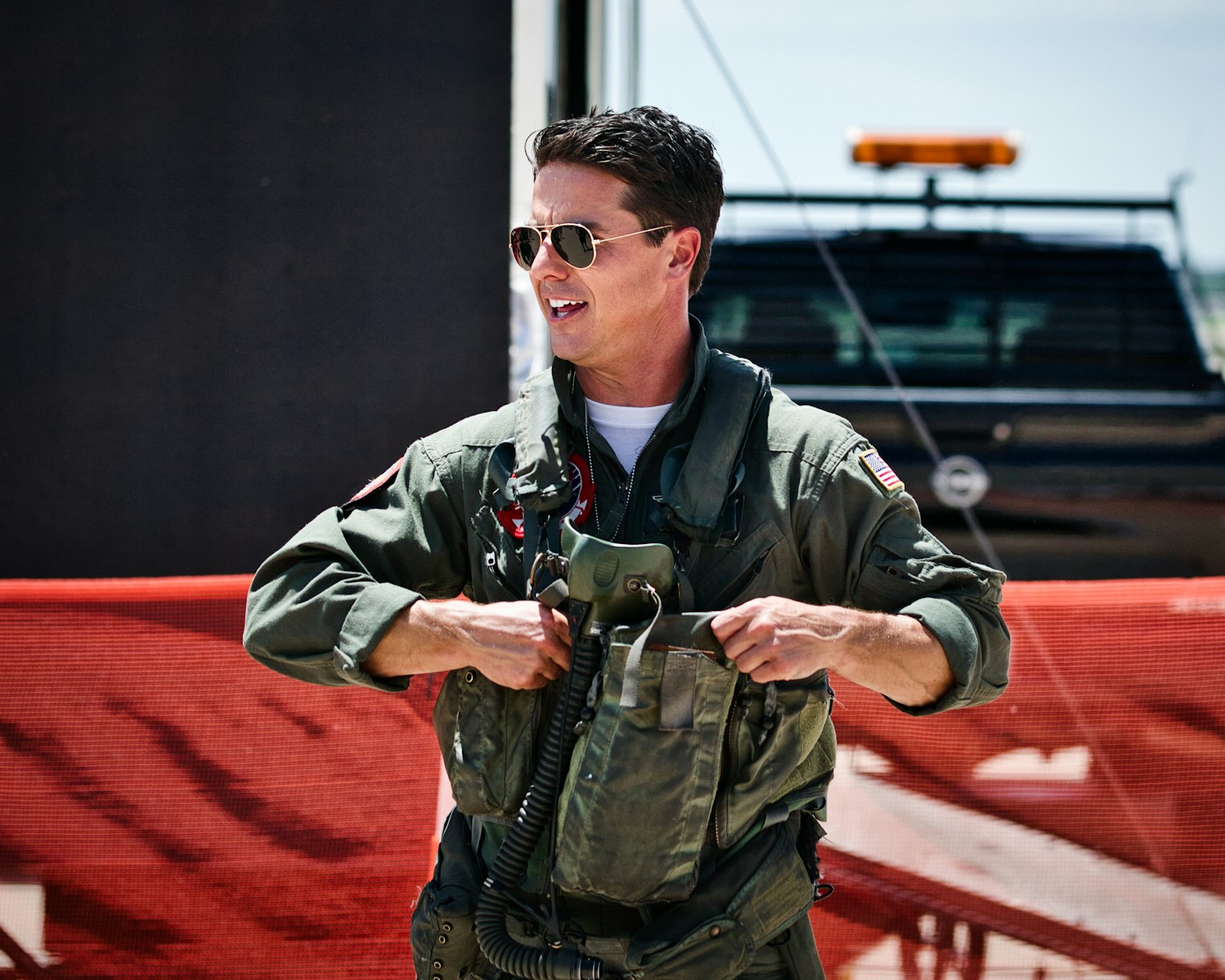 A smiling pilot puts on his flight gear