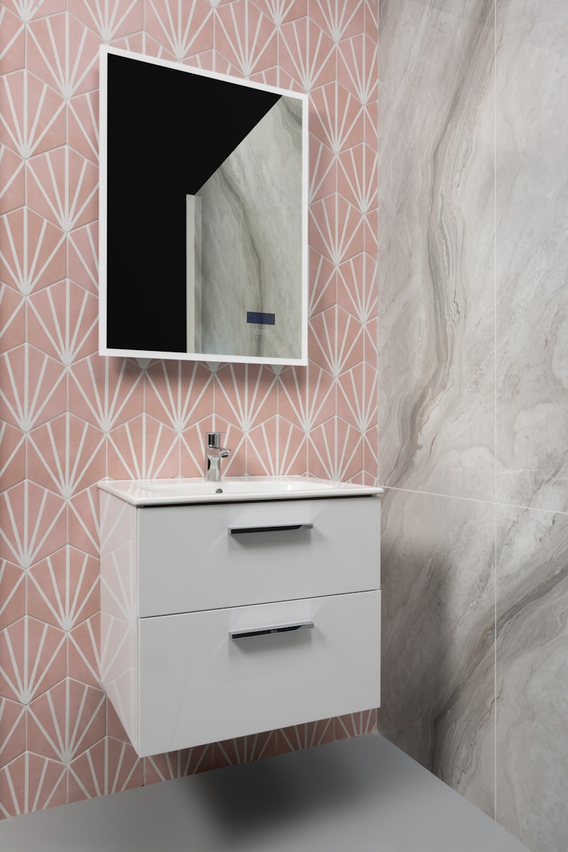 Modern bathroom with pink geometric tiles, vanity, and mirror