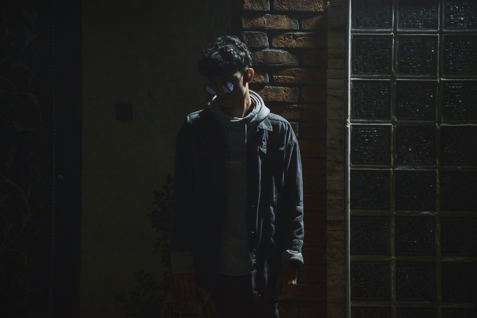 a man standing in front of a brick wall