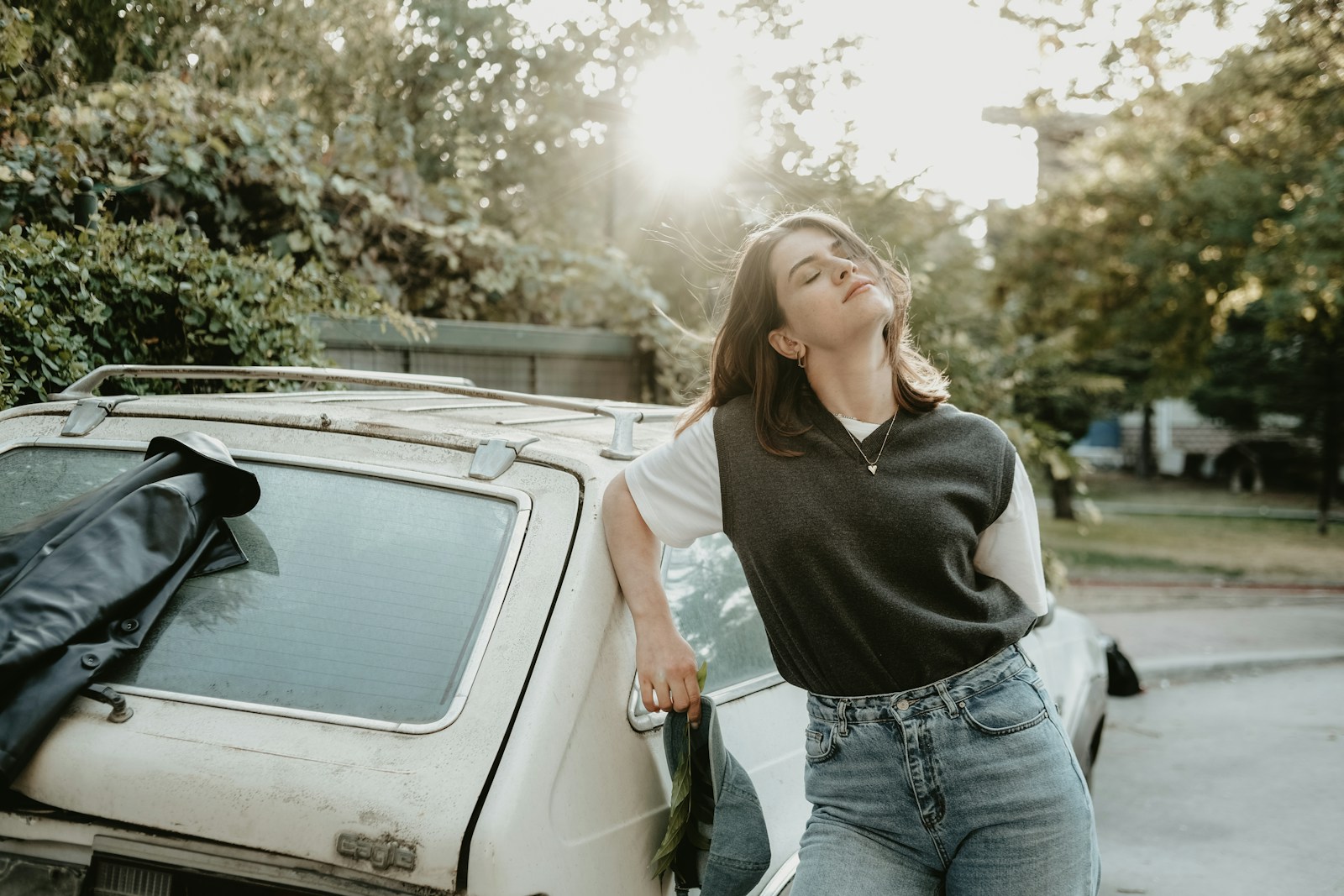 a woman leaning on the hood of a car
