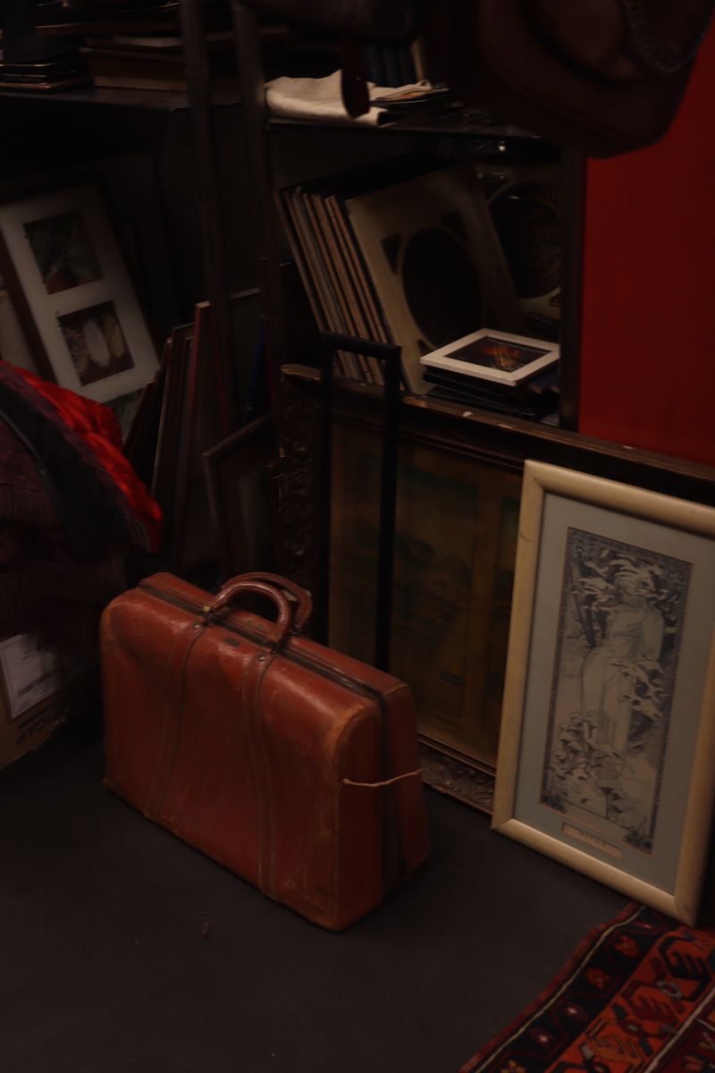 A cozy attic corner featuring a vintage suitcase and framed artwork amid retro decor.