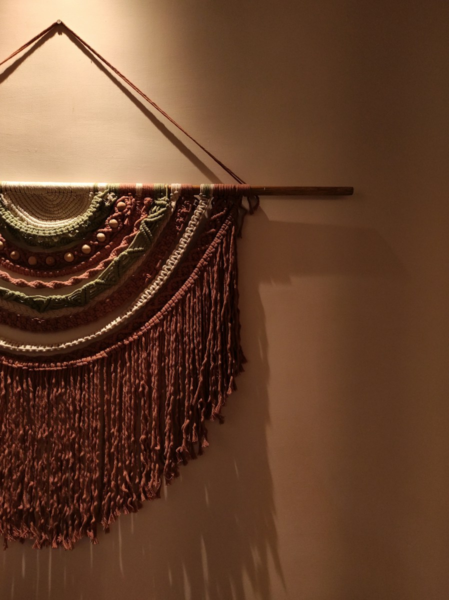 A macrame wall hanging casts a shadow