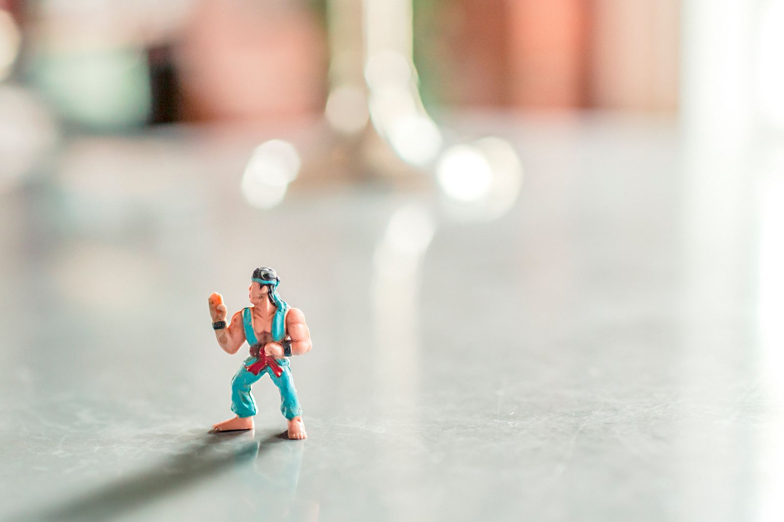 Close-up of a colorful action figure posed on a shiny surface with a blurred background.
