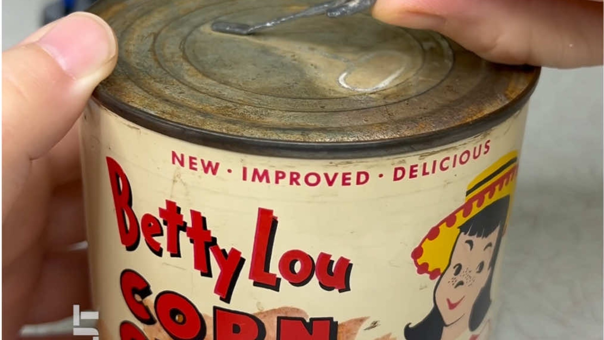 Hands opening a rusted 1950s Betty Lou brand can of corn chips pulled from a fallout shelter