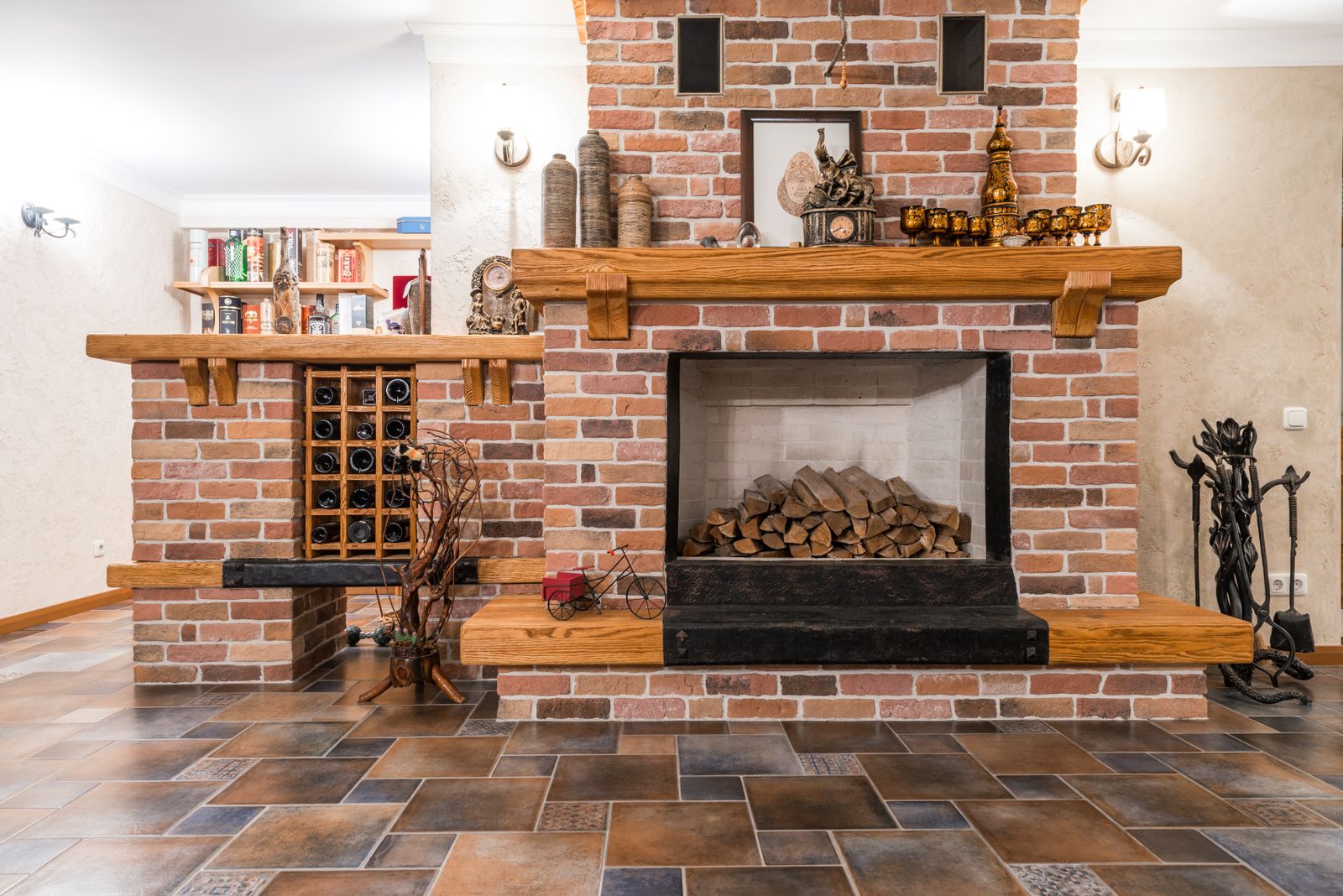 Warm living room with a brick fireplace and neatly stacked firewood, creating a cozy ambiance.