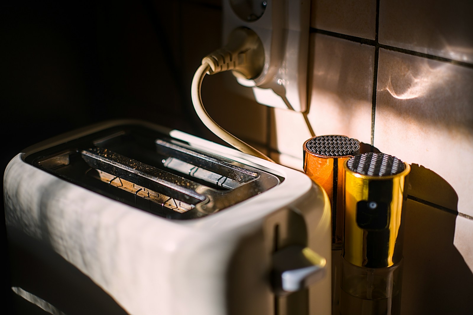 A toaster and mugs sit near a power outlet