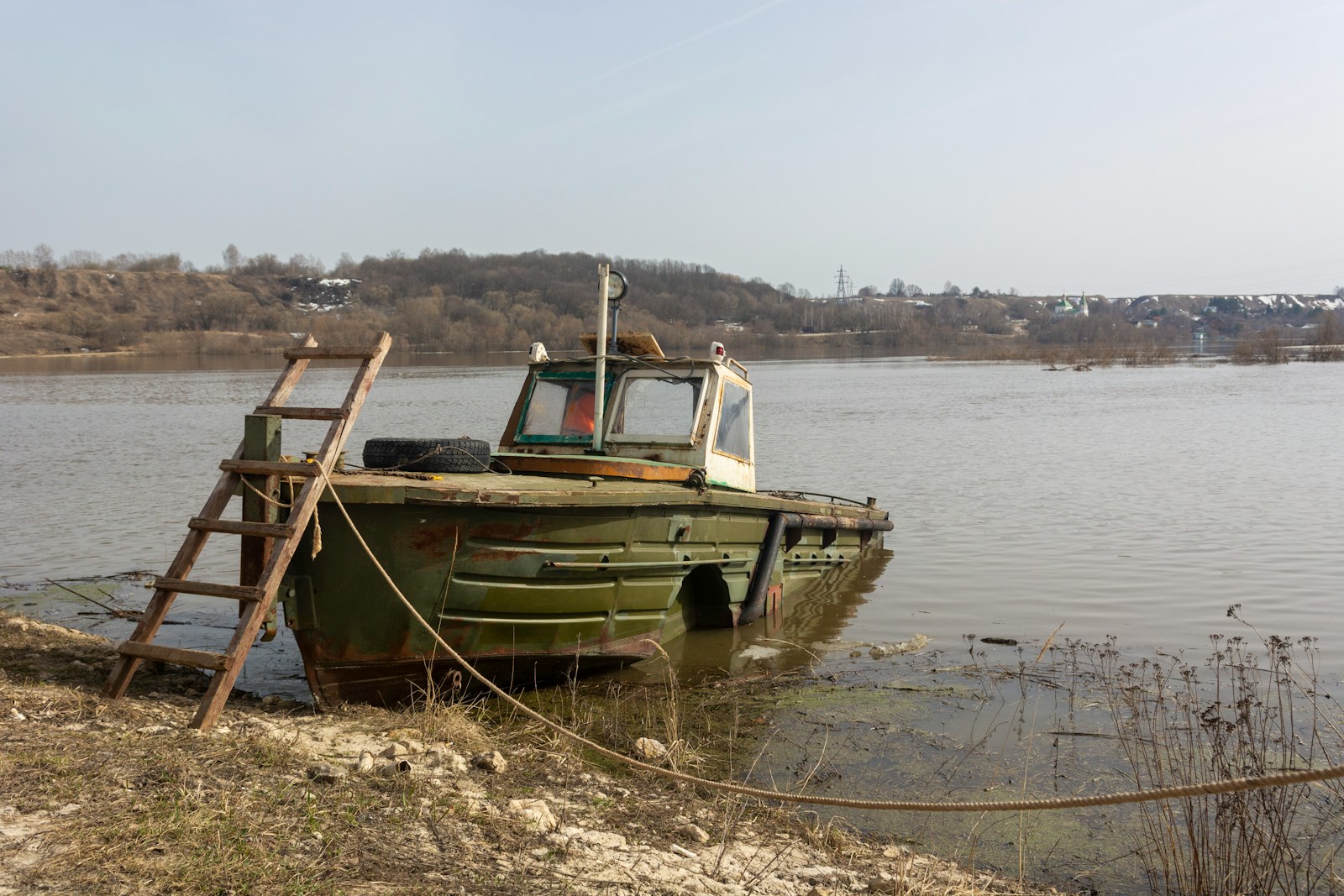 a green boat sitting on top of a body of water