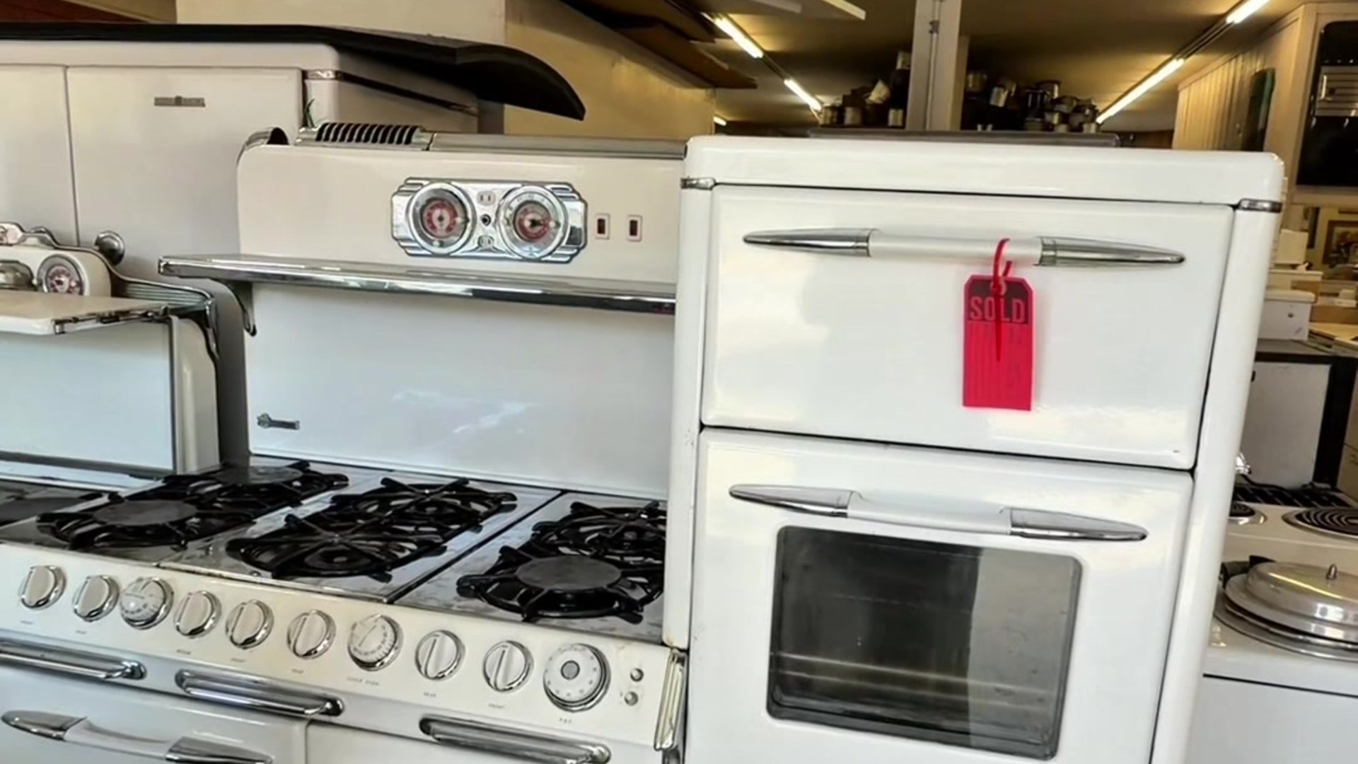 Rows of restored white vintage stoves inside a specialty antique appliance store